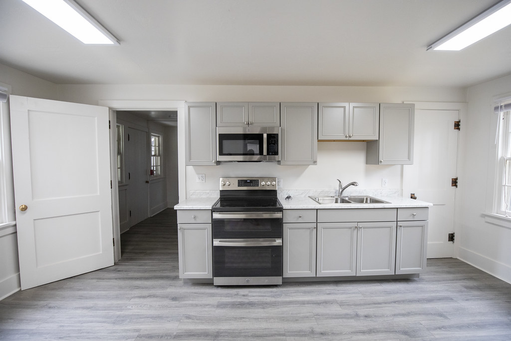 Front-facing view of the renovated kitchen's range, sink and gray cabinets.